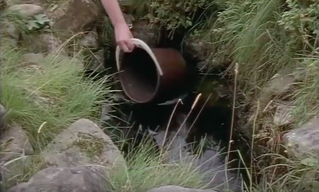 Bucket dipping into natural spring