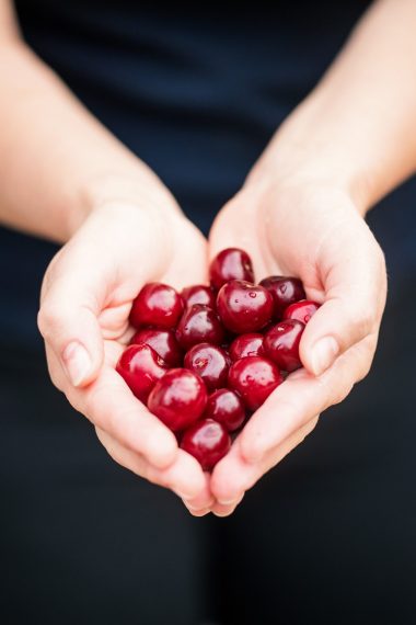 Hands holding cherries